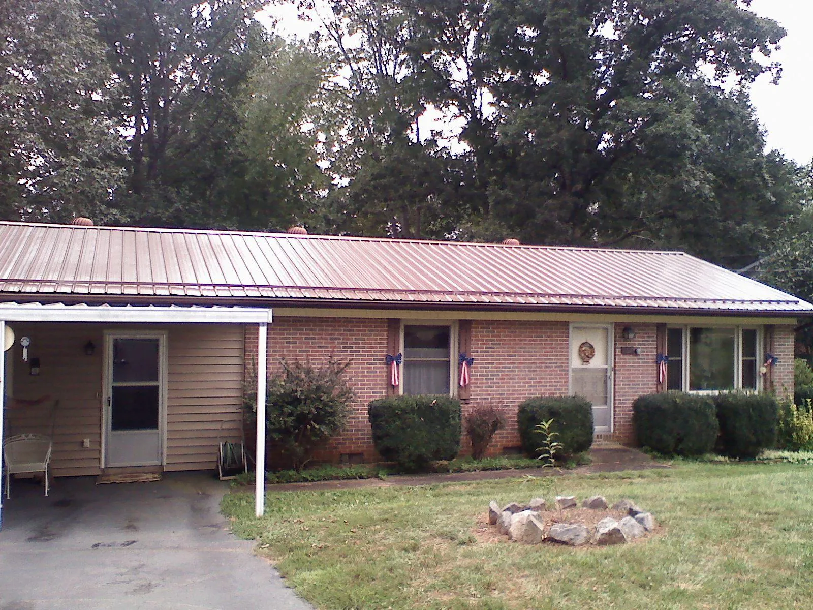 Bronze metal roof and carport on a brick ranch home — Roof Repair work by our crew in Jackson